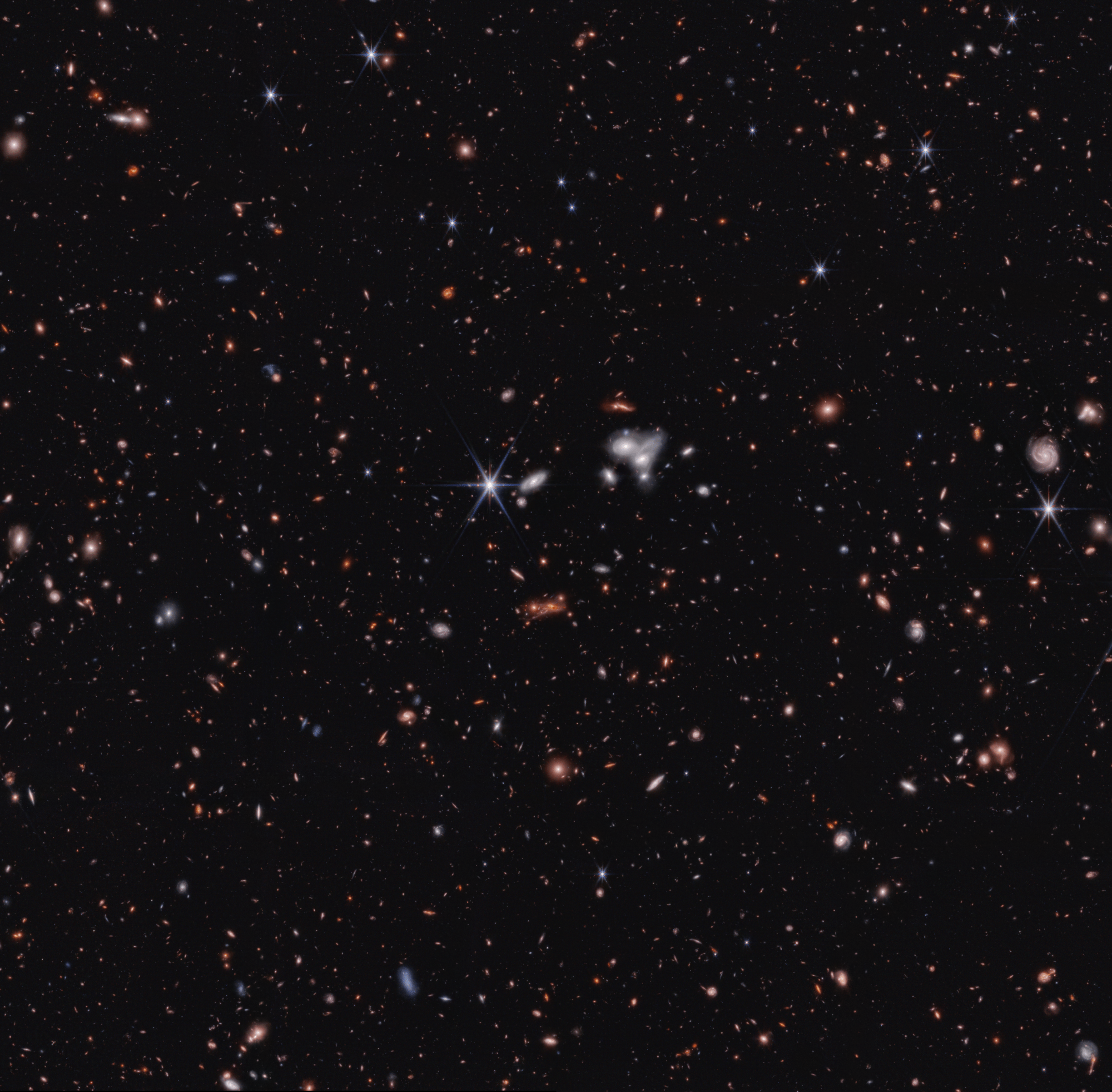 Image of a JWST deep field, showing a lensed cluster of galaxies containing the early black hole CEERS 1019