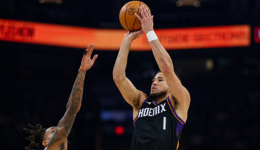 Phoenix Suns guard Devin Booker (1) goes up to shoot over San Antonio Spurs guard Devin Vassell, le...