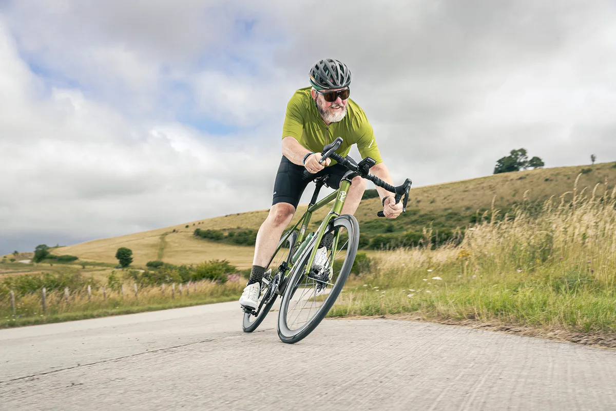 Cyclist (Warren Rossiter) in green riding the custom built Mosaic RT 1TR £15,900