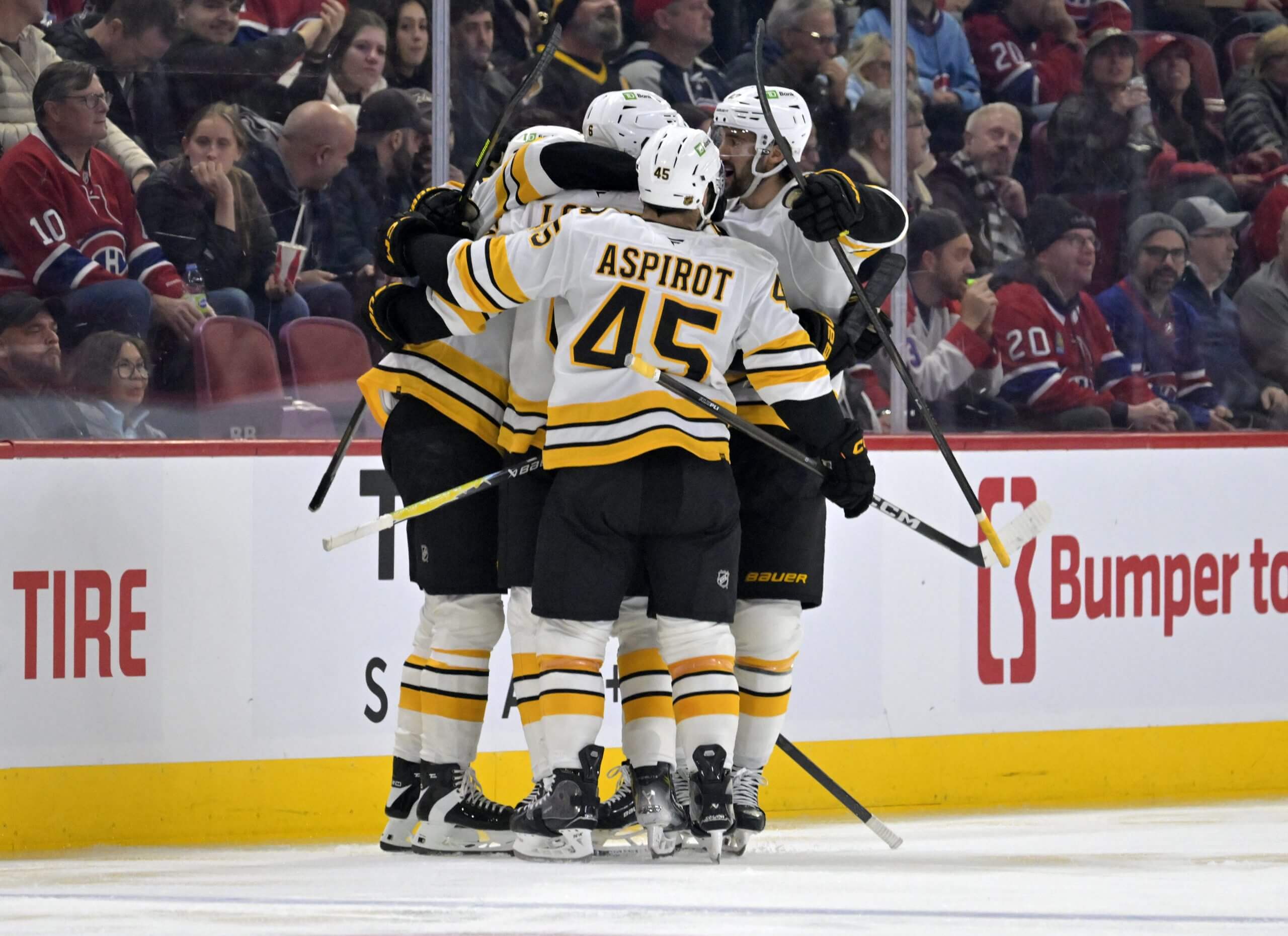 The Bruins celebrate a Mason Lohrei goal with Jonathan Aspirot.