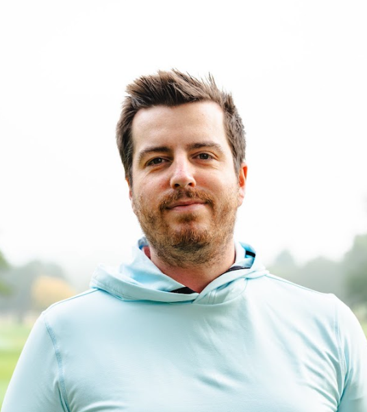 A headshot of Elliott Heath wearing a sky blue hoodie