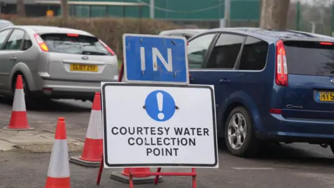 EDDIE MITCHELL A queue of cars at a bottled water collection point.