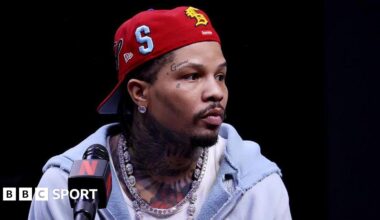 Gervonta Davis wearing a red baseball cap backwards with a grey hoodie