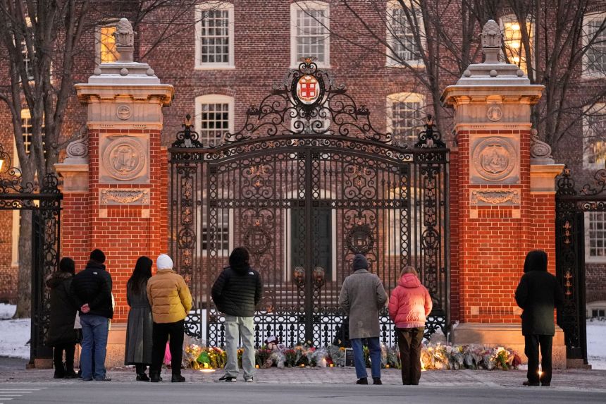 Visitors pause at a makeshift memorial for the victims the shooting at Brown University, on December 15.