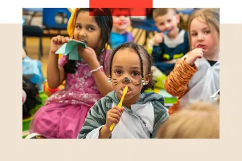 PA Children sit on the floor of a nursery