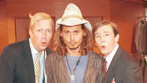 BBC Mark Williams, Johnny Depp and Paul Whitehouse in the suits you sketch from the Christmas 2000 special - Williams and Whitehouse are in their black suits, Depp wears a Stetson hat, a striped shirt and a blue T-shirt. Williams and Whitehouse are making an "Oooh" face.