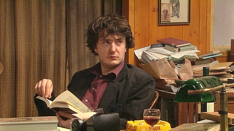Bernard Black (Dylan Moran) reads with disdain in Black Books
