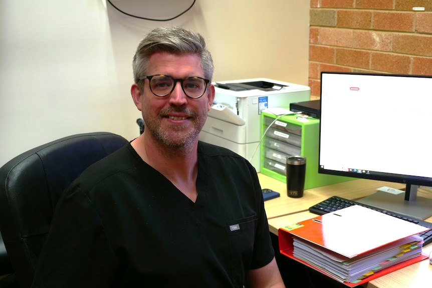 Doctor Luke Talbot sitting at a desk 