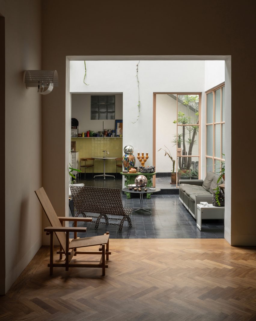 Balcony with dark floor tiles viewed from a living space with herringbone parquet