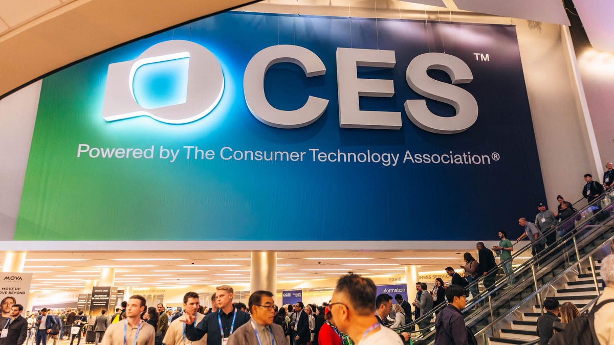 A large CES banner above a room full of people and an escalator.