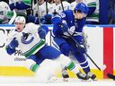 Vancouver Canucks' Linus Karlsson (94) and Toronto Maple Leafs' Matthew Knies (23) collide during first period NHL hockey action in Toronto on Saturday, Jan. 10, 2026.
