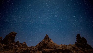 interesting rock formations with jagged peaks and a starry sky above.