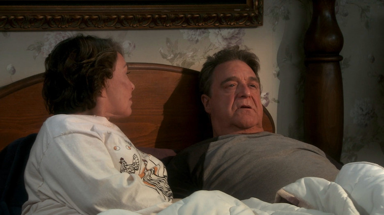 Roseanne Barr as Roseanne sitting in bed looking at John Goodman as Dan in Roseanne