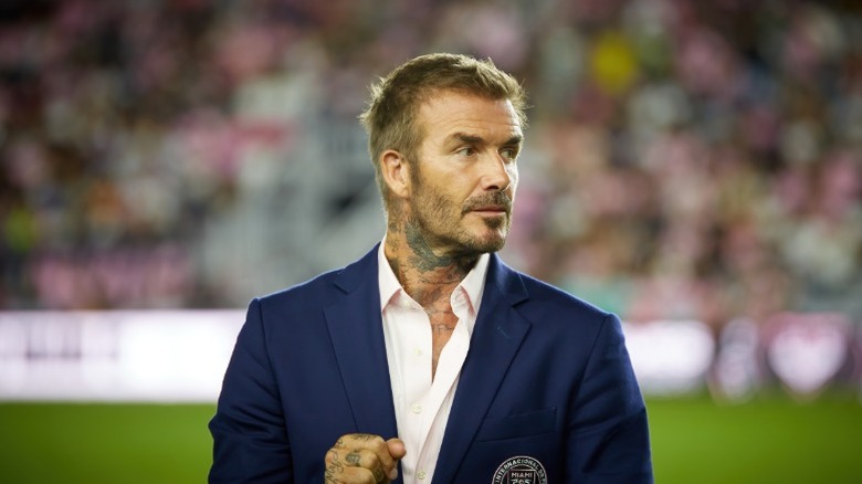 David Beckham wearing a suit in a stadium
