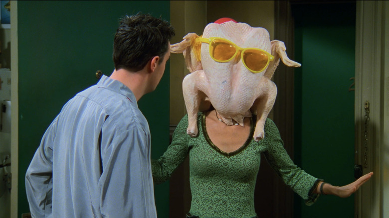 Courteney Cox's Monica Gellar wears a turkey on here head as Matthew Perry's Chandler Bing watches in Friends