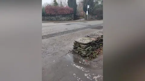 Sewage in street which is coming out of a manhole on a road in Staveley.