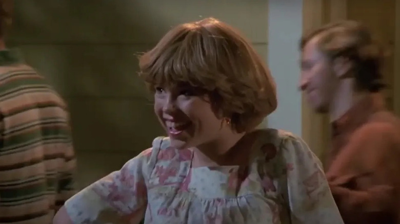 Amanda Fuller with short hair as Tina smiling with short and blurred people next to her in That '70s Show