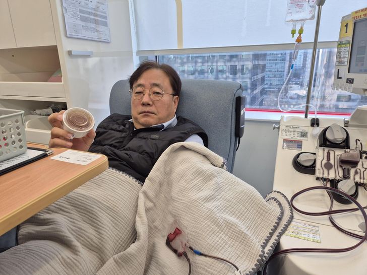 Yang Chung-mo, a 59-year-old  blood donor, poses with a Dubai chewy cookie he received at the Gwanghwamun Blood Donation Center in Jongno District, central Seoul, Friday. Korea Times photo by Park Ung 