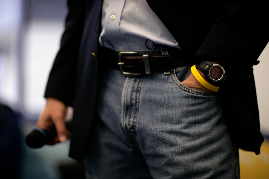 A man wears a yellow livestrong bracelet