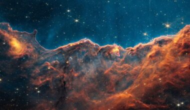 orange clouds of dust in space look like mountains in the JWST image