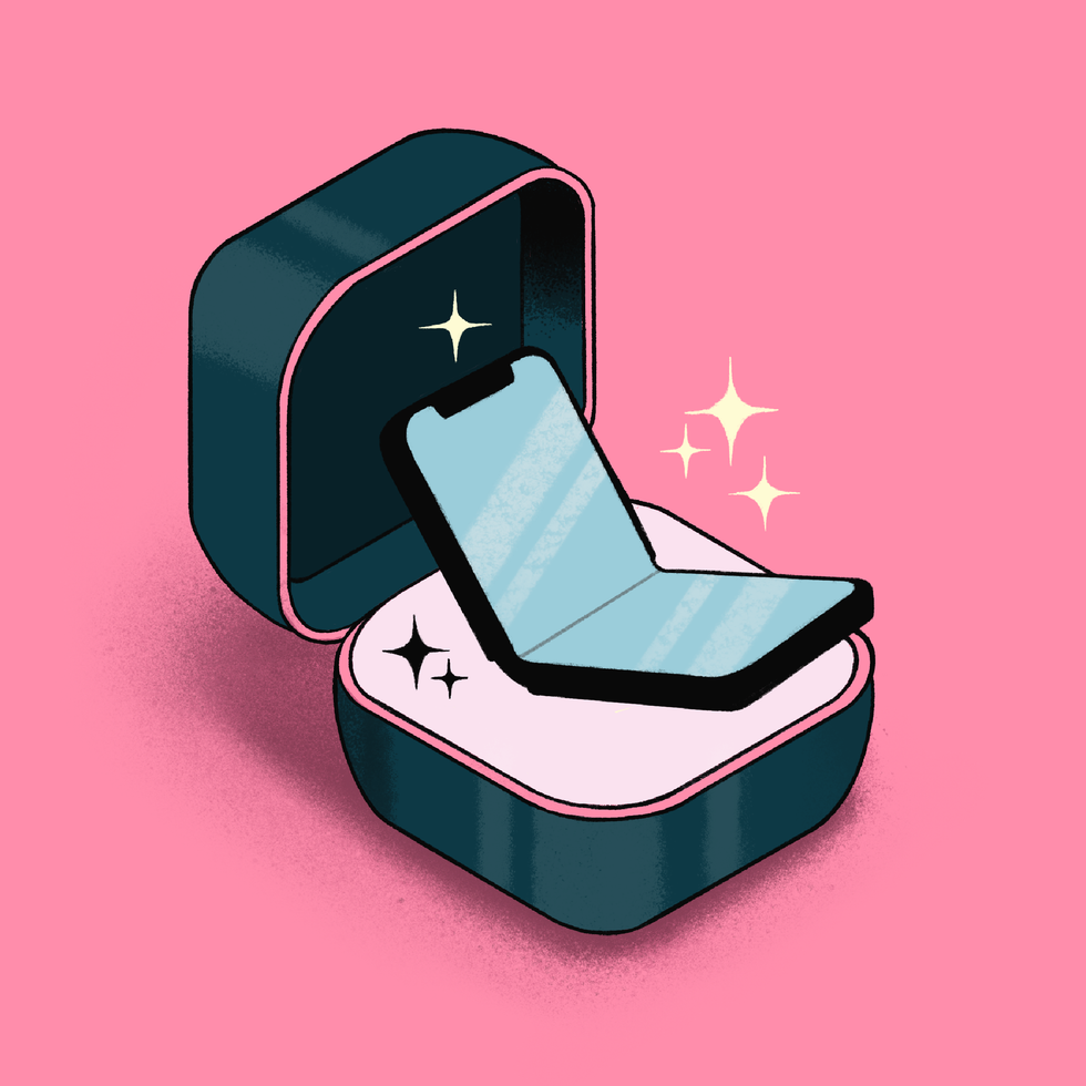 Foldable phone in a jewelry box on pink background, with sparkling effects.