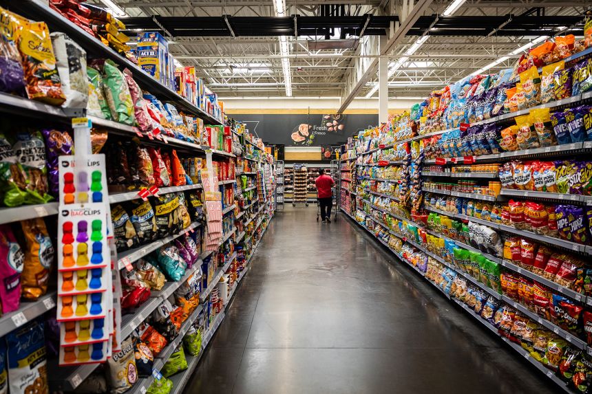 A customer walks in the snack aisle of a Walmart. The chain's private label line is doubling down on wellness products.