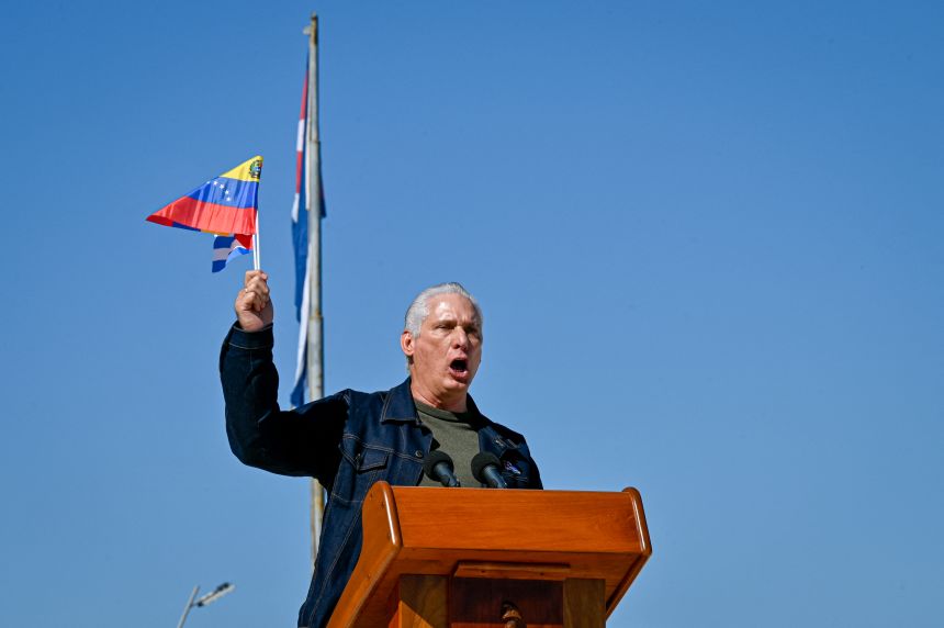 Cuba's President Miguel Diaz-Canel delivers a speech as he flutters a Venezuelan national flag in support of Venezuelan leader Nicolás Maduro in Havana, on January 3, 2026.