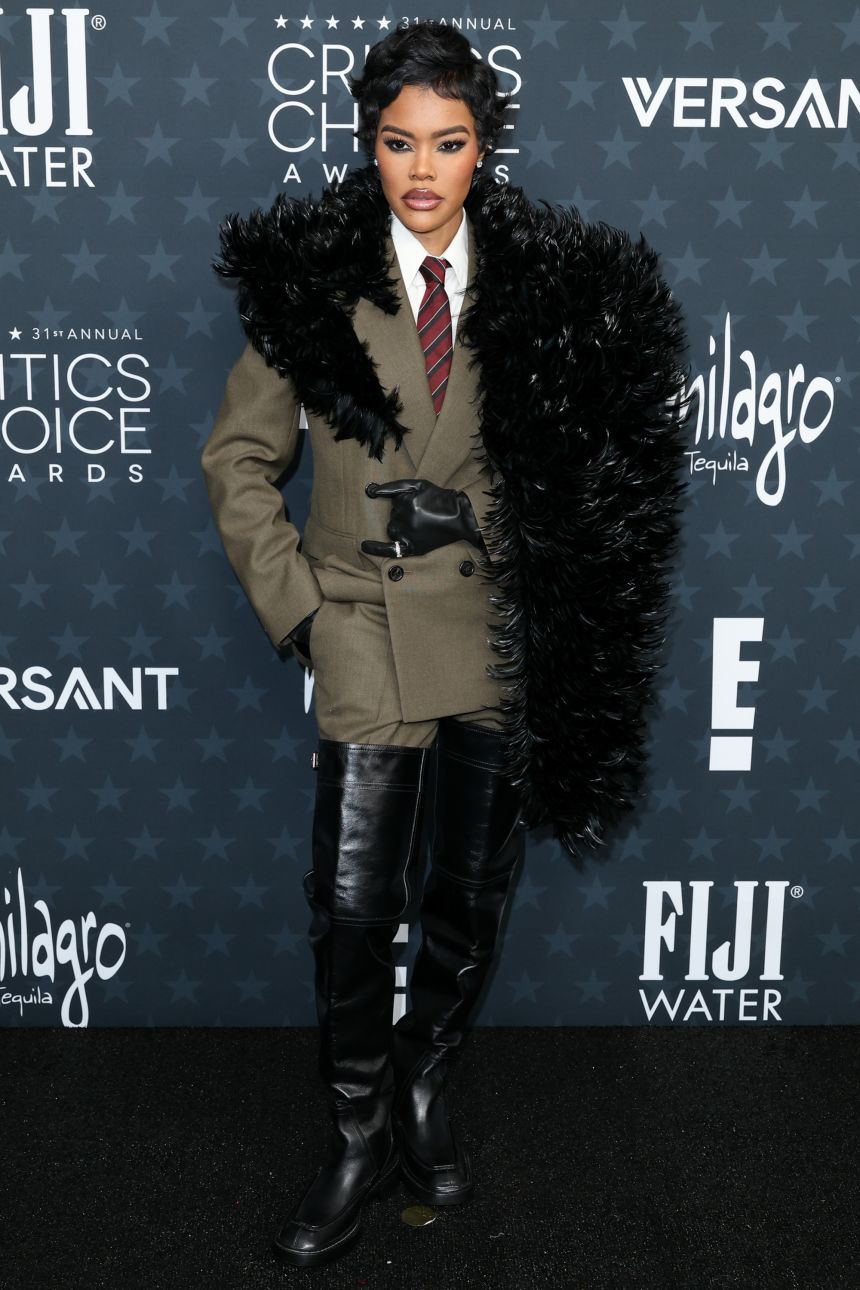 Complete with leather gloves, thigh-high boots and striped necktie, Teyana Taylor's feathery suit was adapted from Saint Laurent's Fall-Winter 2025 menswear line.