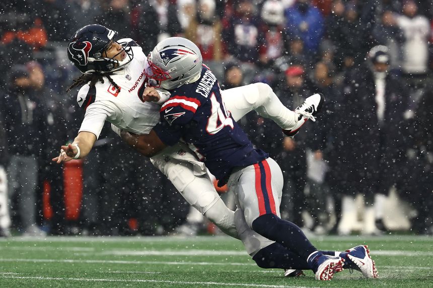 Houston Texans quarterback CJ Stroud is leveled by the New England Patriots' K'lavon Chaisson during their playoff game on Sunday. Stroud threw an interception on the play that was returned for a touchdown.