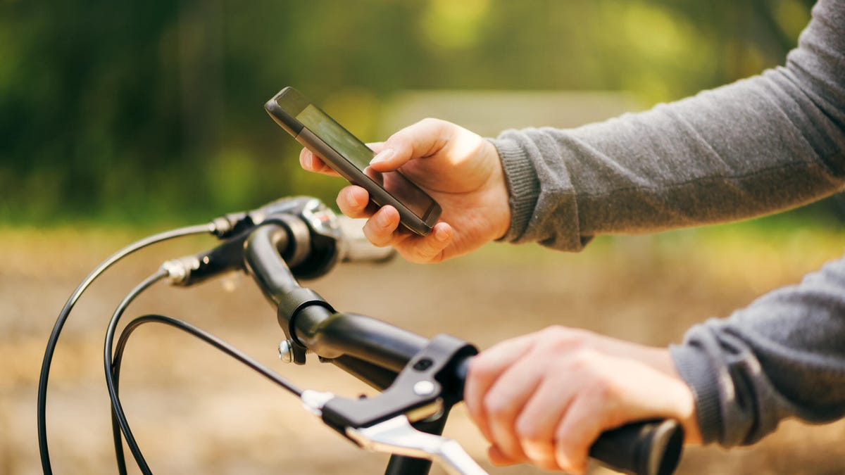 Woman typing text message during bicycle ride