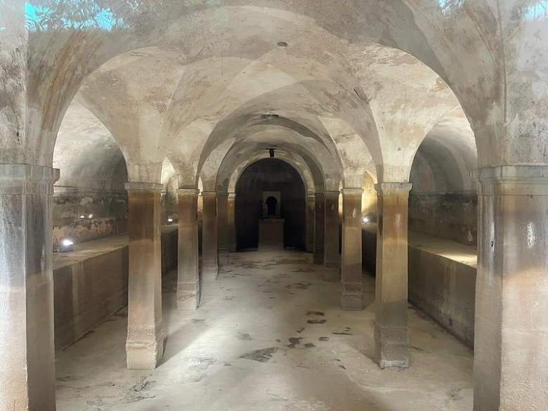 A vaulted interior space, built out of stone or concrete.