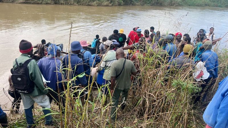 A section of the crowd of residents who gathered to collect meat from the dead hippo on the banks of the iMfolozi River in the iSimangaliso World Heritage Site near the town of Mtubatuba, northern KwaZulu-Natal. (Photo: Supplied)
