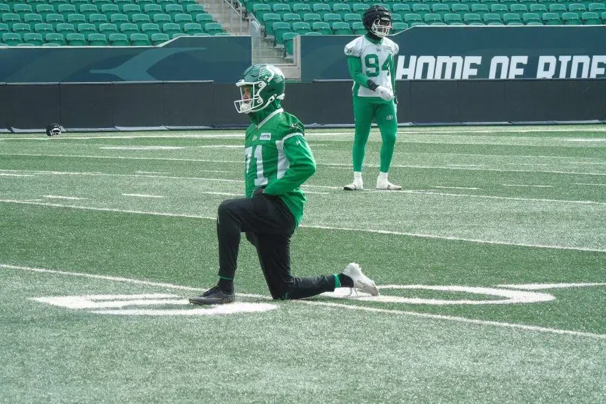 Michael Hughes kneels on the field at Mosaic Stadium.