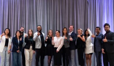 A group of well-dressed people standing in a line, smiling.