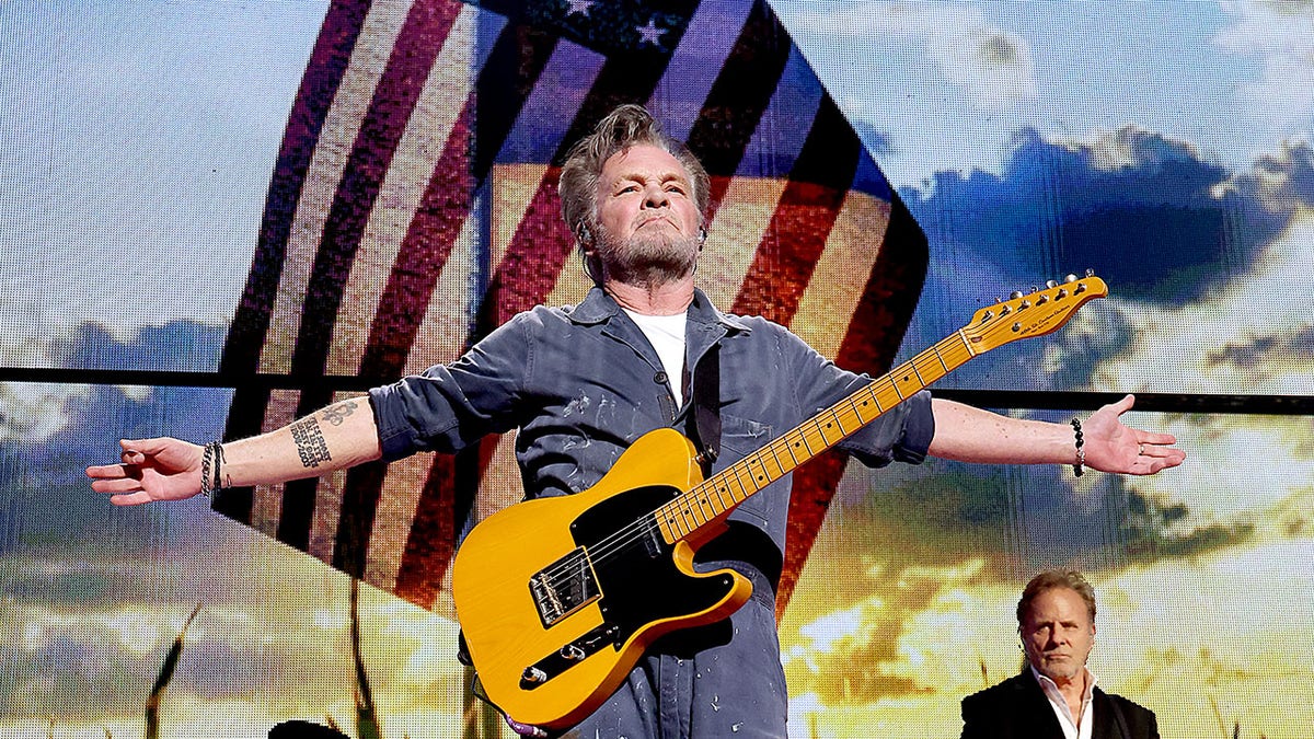 John Mellencamp performing in 2023 in front of the American flag