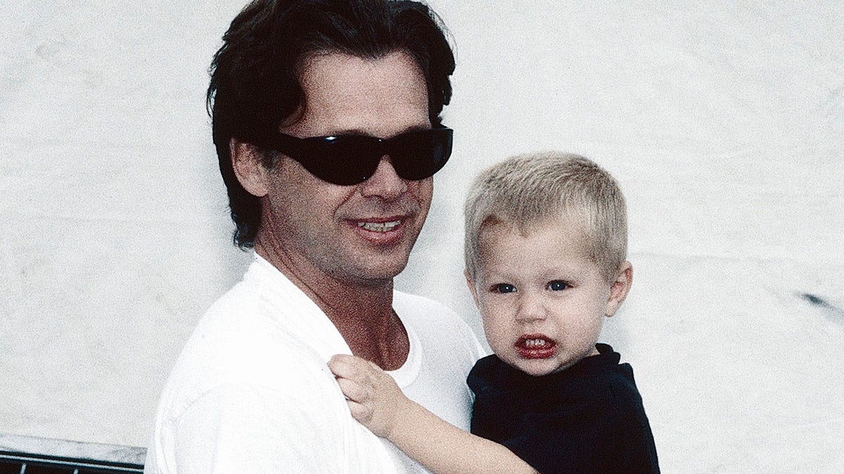 John Mellencamp holding his son, Hud, in 1996