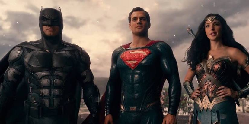 Batman, Superman, and Wonder Woman standing together triumphantly and staring off at something in Justice League 2017.