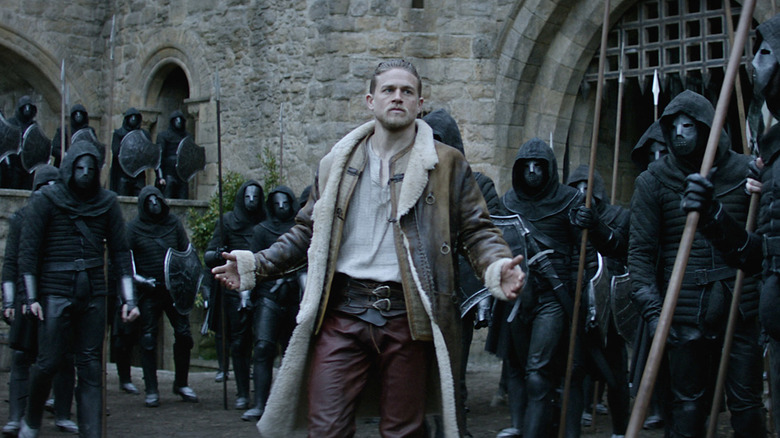 Arthur standing amongst black clad warriors in King Arthur: Legend of the Sword (2017)