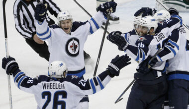 Winnipeg Jets center Bryan Little, center, and right wing Blake Wheeler celebrate with left wing Andrew Ladd and other teammates after Ladd's game-winning goal against Minnesota Wild goalie John Curry during overtime on Saturday. (Ann Heisenfelt/AP)