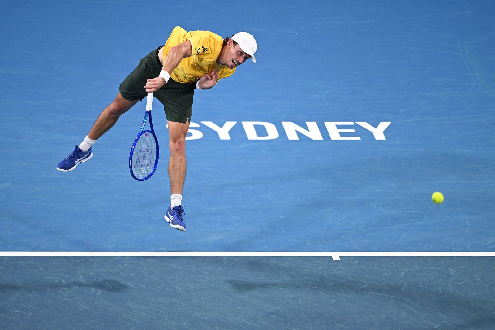 Alex de Minaur hitting a tennis shot on court with his whole body in the air