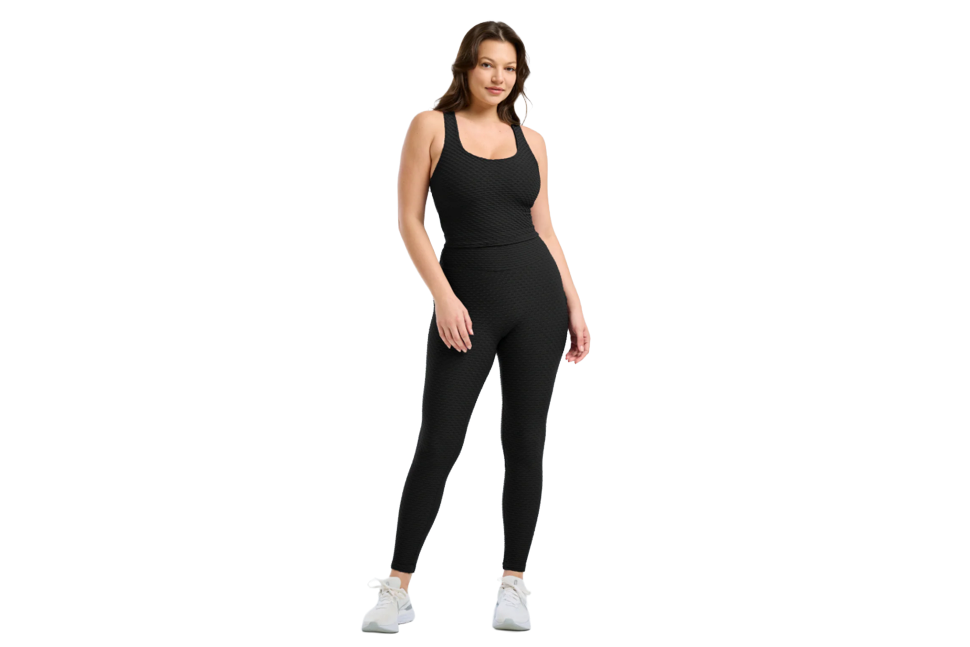 A woman wearing a black textured sports bra and matching leggings.