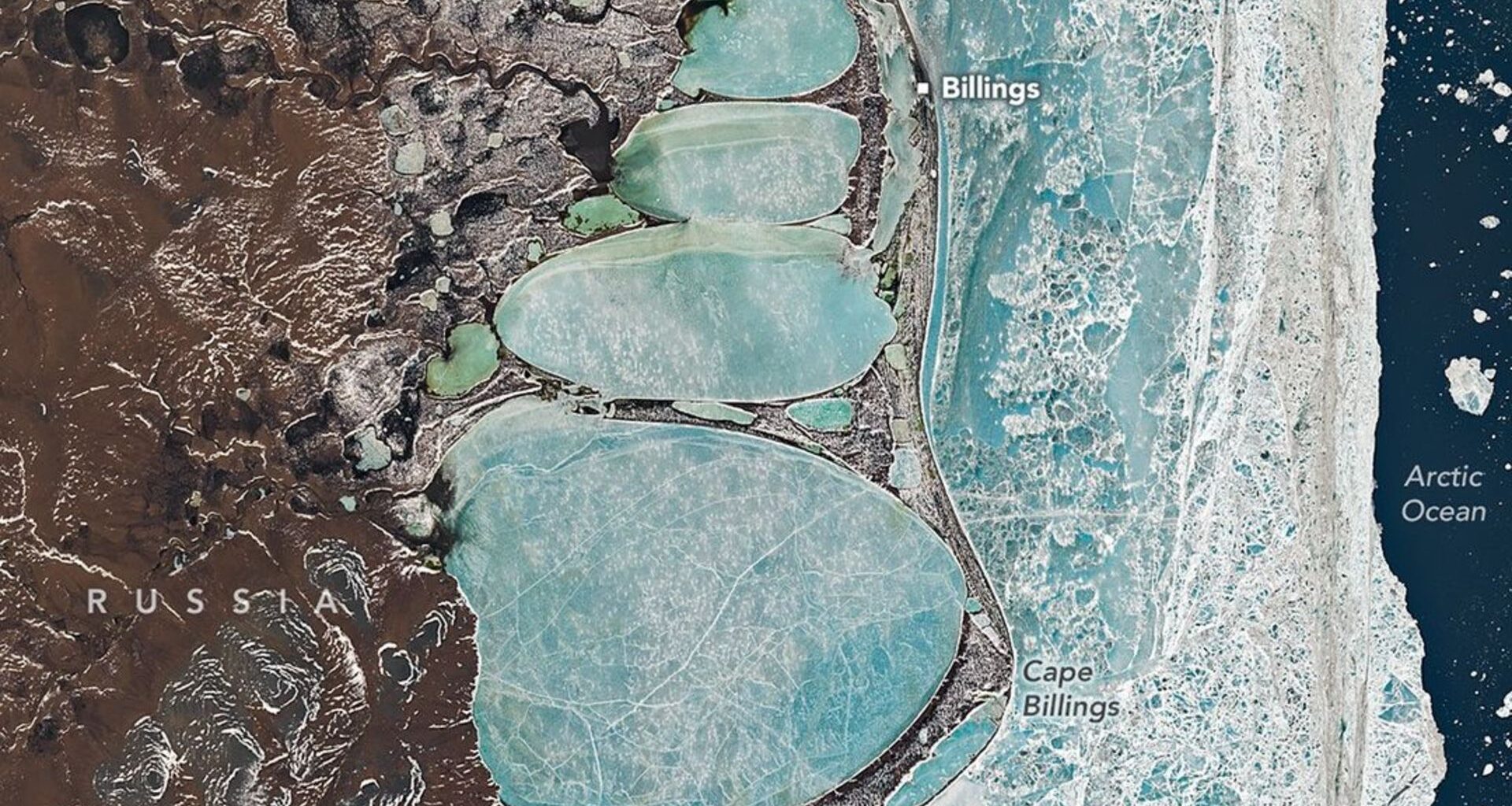 A photo of Earth from space where four snowy circles are seen against the labeled coastline of Russia with a dark blue ocean on the right of the image