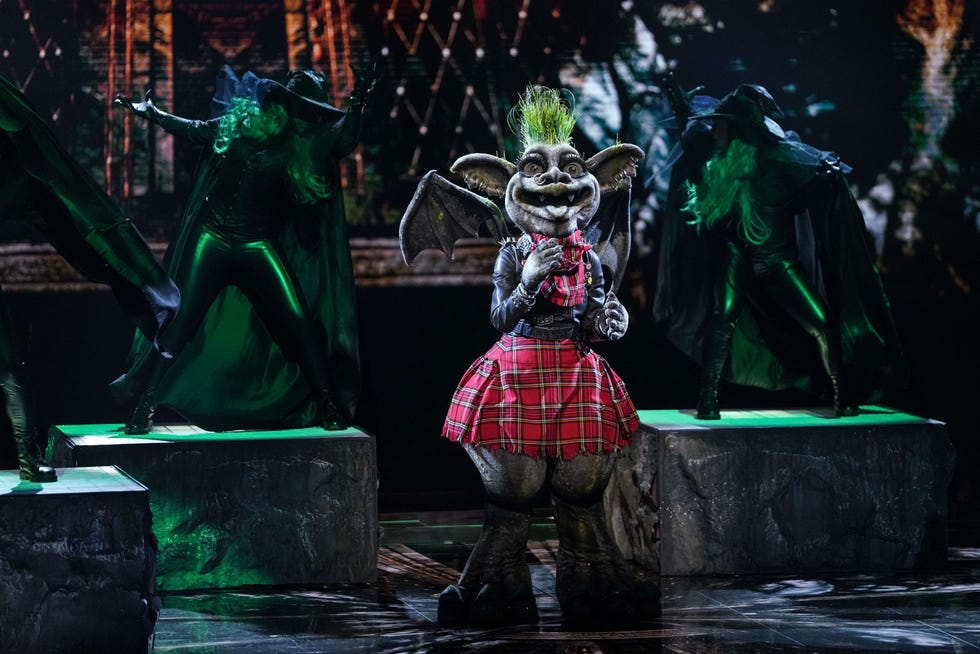 a performing character in a plaid skirt with monstrous features and stylized attire
