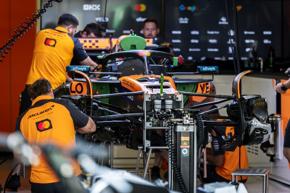 McLaren F1 Team engineers and MCL39 in the garage during the... mclaren f1 team engineers and mcl39 in the garage during the...