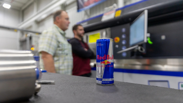 Red Bull can on a table while Ford engineers stare at a screen