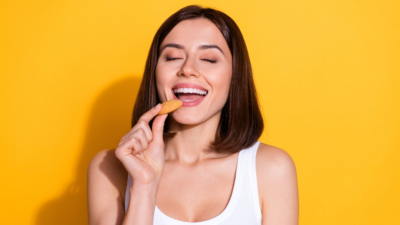 Portrait of woman biting into cookie
