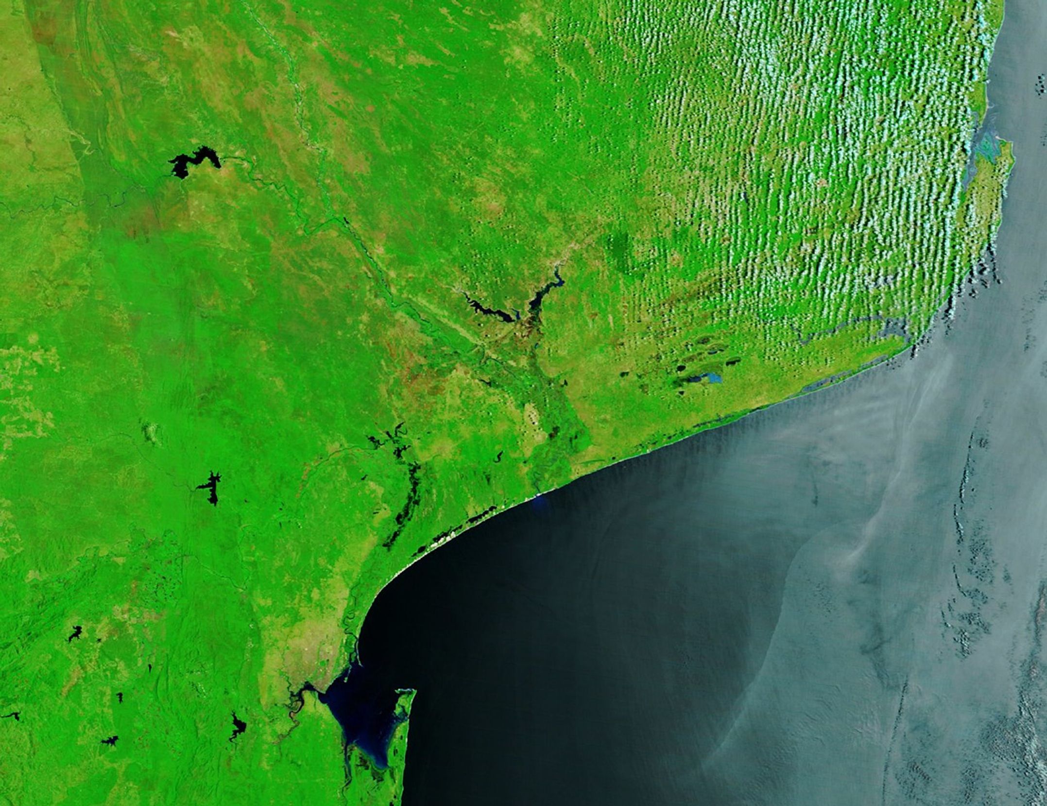 In an image of the same area captured before the flooding on December 17, 2025, a thin line of river water runs down the center of otherwise dry floodplains.