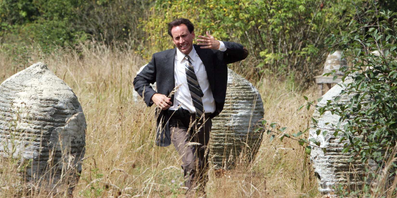 Nicolas Cage as Edward Malus running in an open field in The Wicker Man