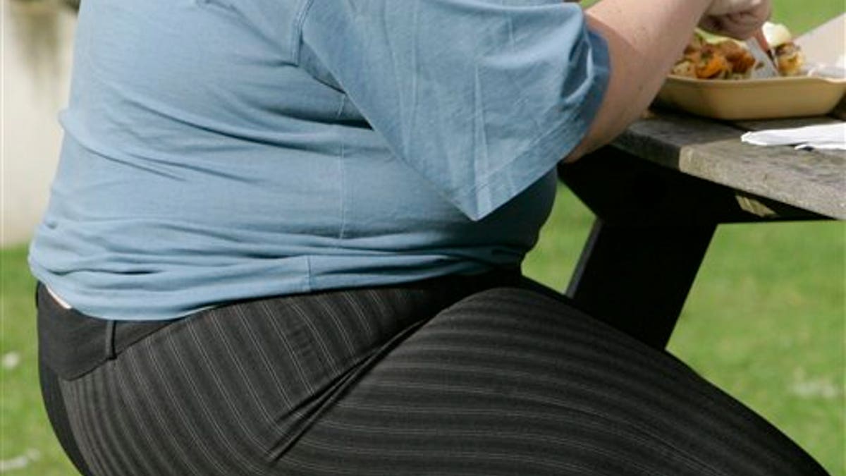 FILE - In this Wednesday, Oct. 17, 2007 file photo, an overweight person eats at a bench in London. The European Court of Justice says obesity can be a disability, a ruling that could have consequences for employers across the continent. The court ruled Thursday, Dec. 18, 2014 in the case of a Danish child-minder who says he was unfairly fired for being fat. The court said if obesity hinders "full and effective participation in professional life, it could count as a disability. Discrimination on the grounds of disability is illegal under European Union law. (AP Photo/Kirsty Wigglesworth, file)