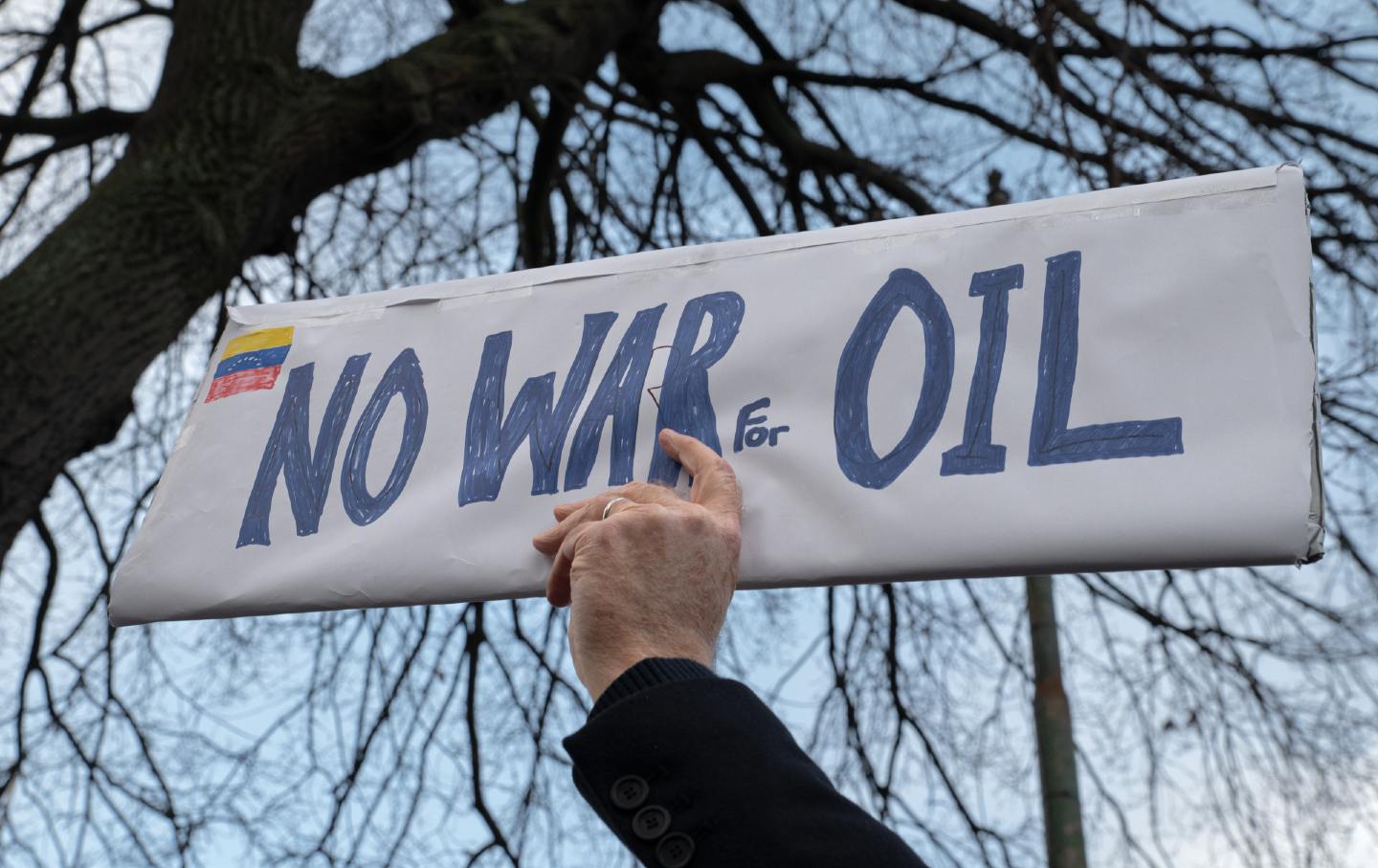 A man holds a plaque reading “No War for Oil” in front of the US Embassy in Dublin.